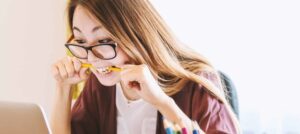 Stressed Student biting a pencil worrying about academic proofreading ethics